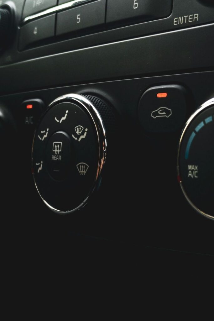 Detailed close-up of car dashboard controls featuring buttons, dials, and indicators.